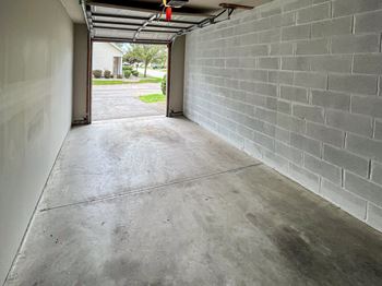 Attached 1-car garage with open garage door and view of driveway